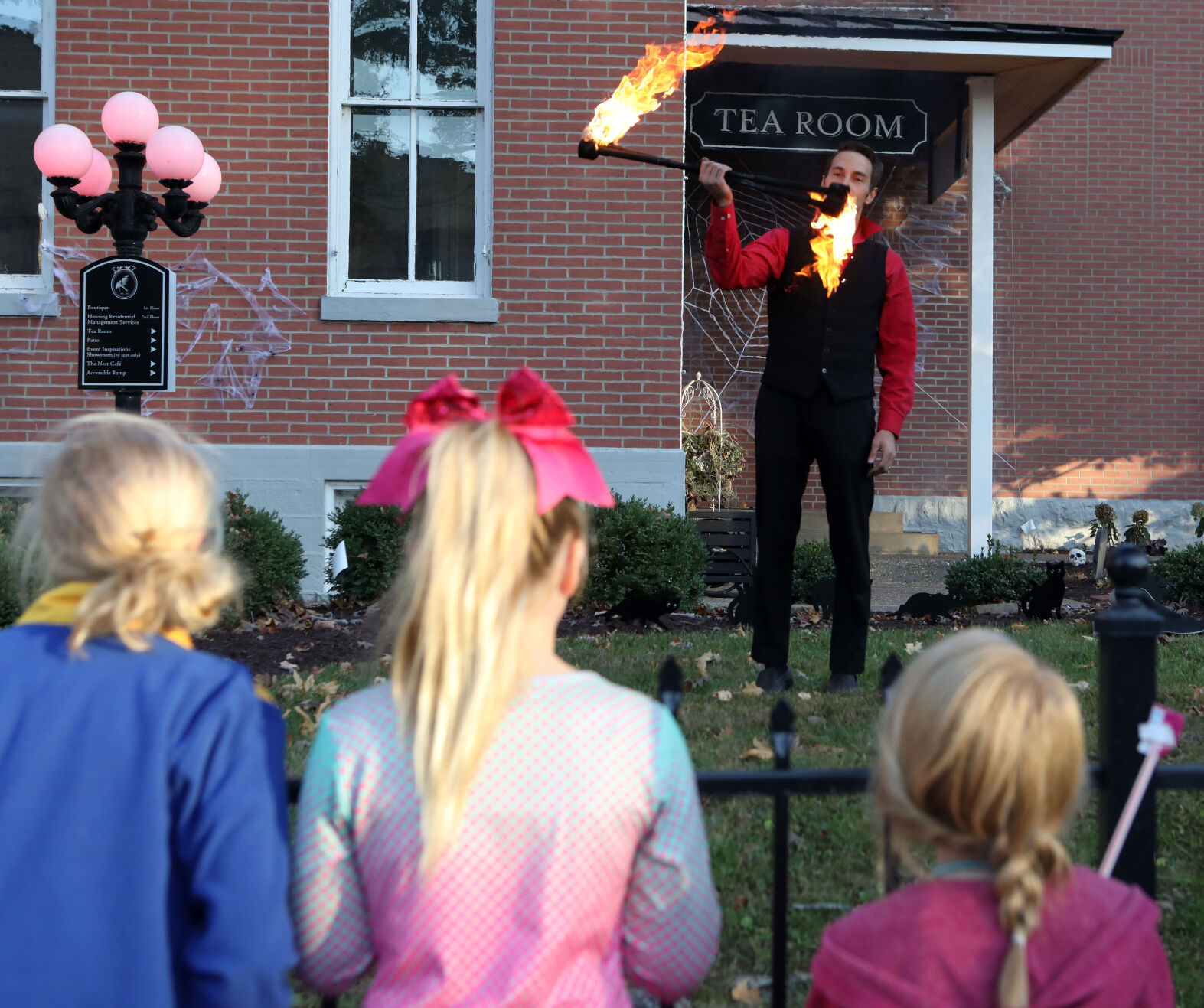 Three girls watch as a fire handler performs